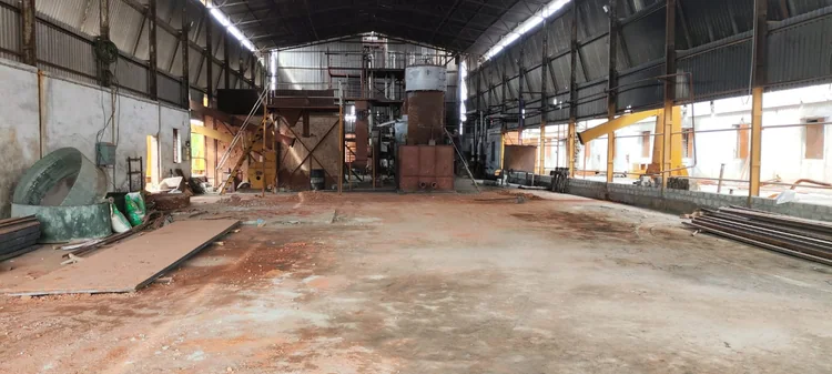 A wide view of the manufacturing hall with machinery, walkways and roof structure