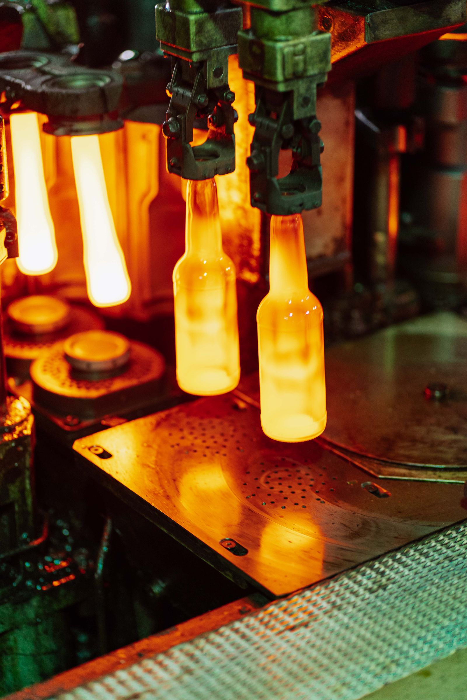 Glowing glass bottles moving through a factory production line