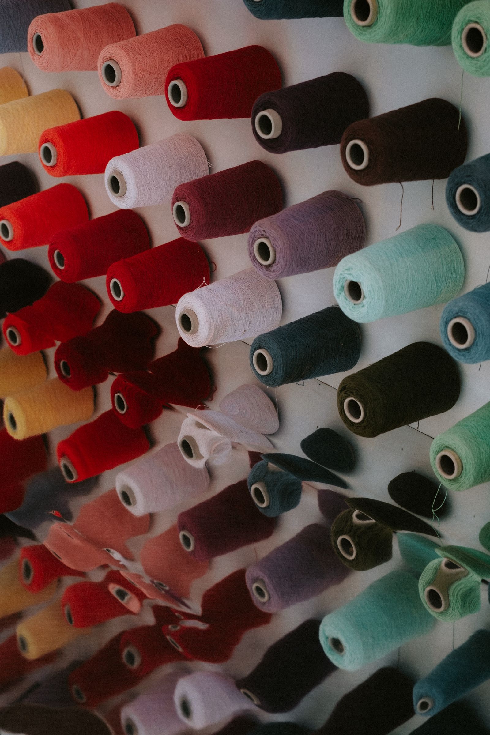 Rows of colourful yarn spools displayed in a textile shop